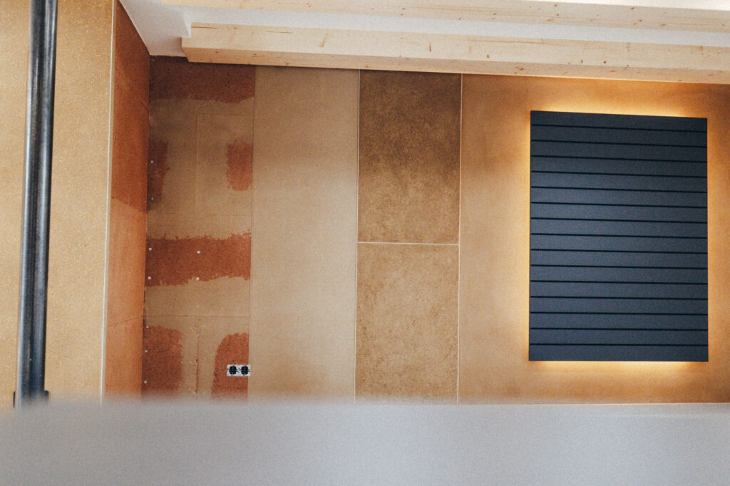 Detailaufnahme einzelner Stadien einer Wand, die mit Lehmputz verputzt wird